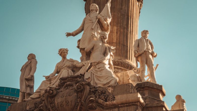 Bronze statues representing Law War Justice and Peace at the base of Angel of Independence