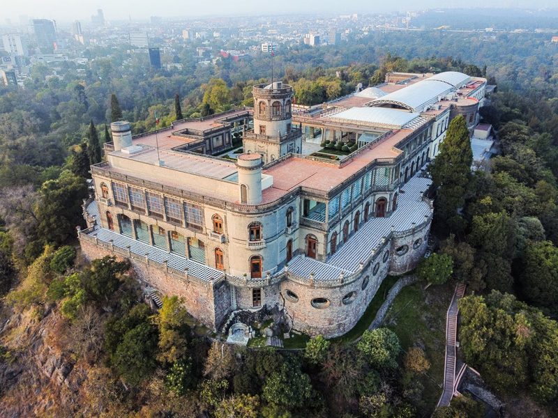 Stunning aerial view of historic Chapultepec Castle surrounded by lush forest in Mexico City