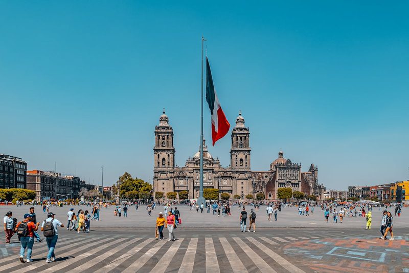 Bustling Zocalo Square in Mexico City with the Metropolitan Cathedral and Mexican flag