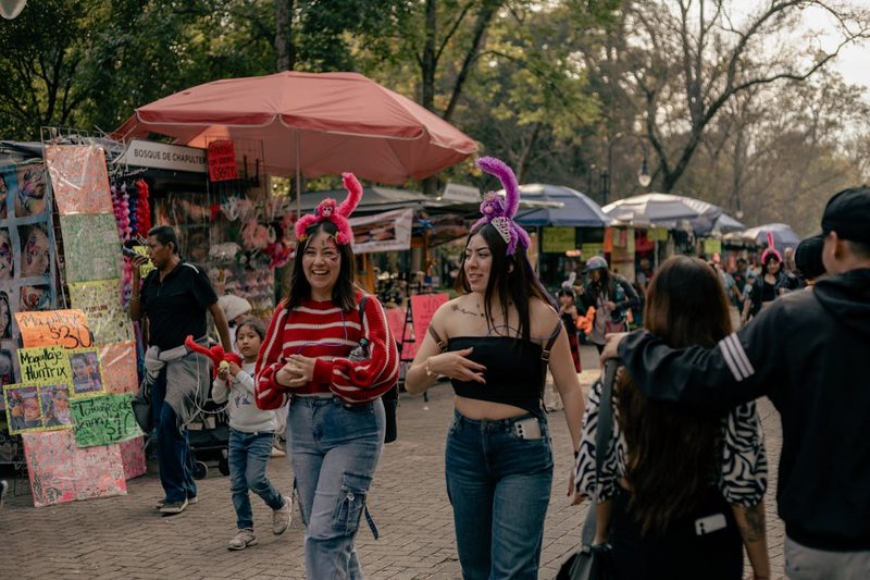 Visitors enjoying a lively street market at Bosque de Chapultepec on a bright day