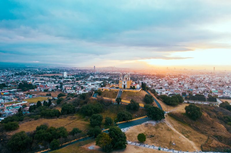 Majestic aerial view of the Great Pyramid of Cholula and surrounding cityscape at sunset