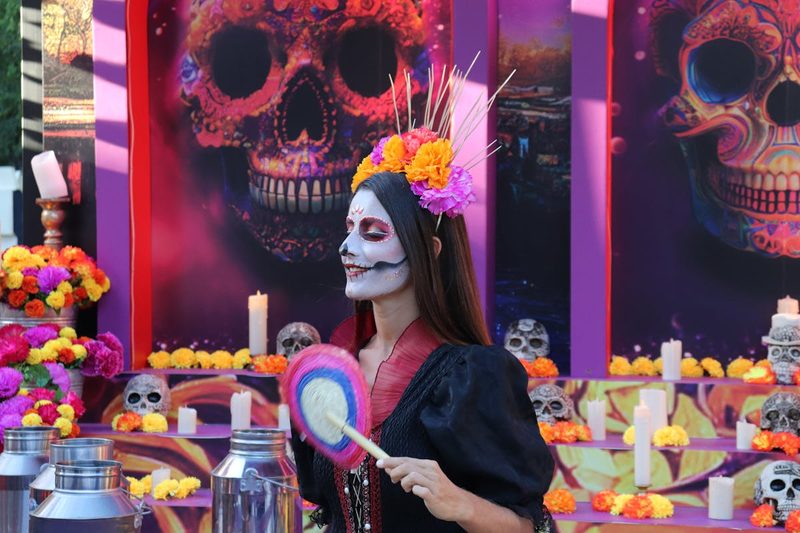 Woman with elaborate Catrina face paint and floral headpiece celebrating Day of the Dead in Mexico