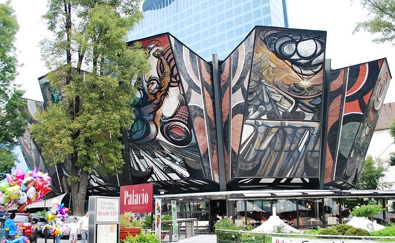 Exterior of the Polyforum Siqueiros cultural center showing the mural-covered facade
