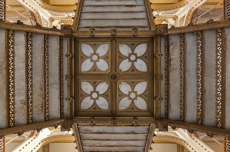 Ornate interior hall of the Palacio Postal showing gilded columns and ceiling details